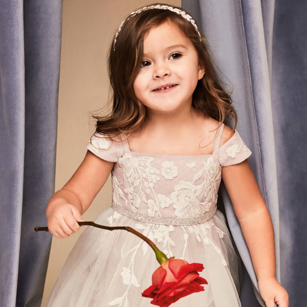 flower girl holding a rose and wearing a headband