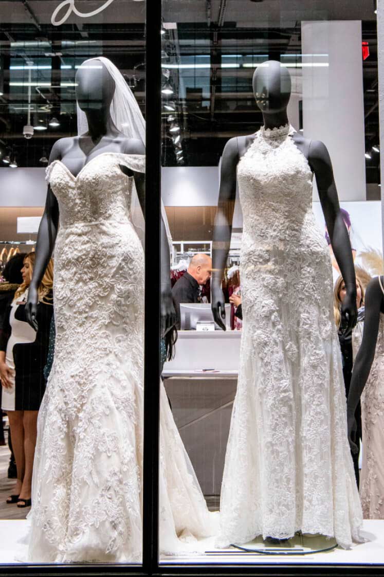 store window display of wedding dresses on mannequins