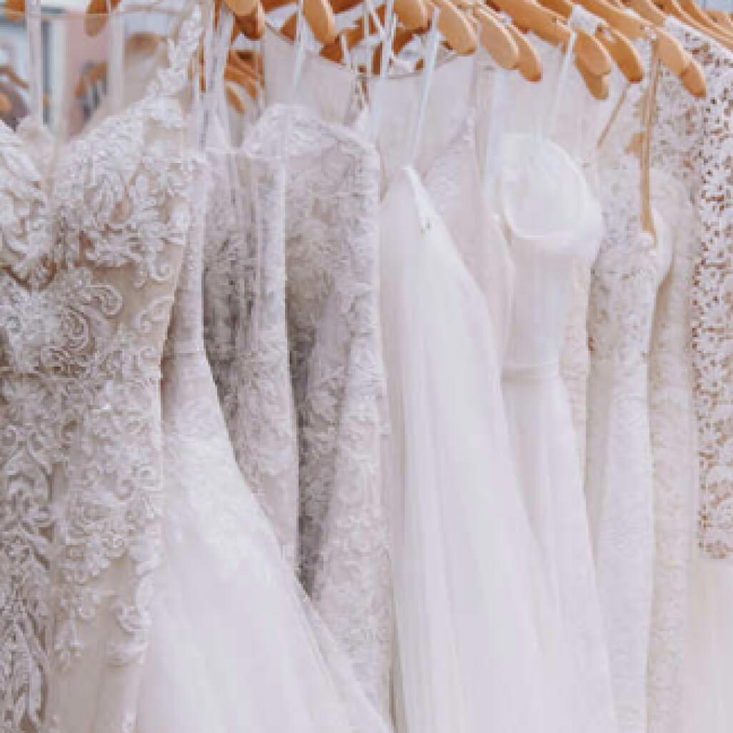 wedding dresses hanging on a dress rack