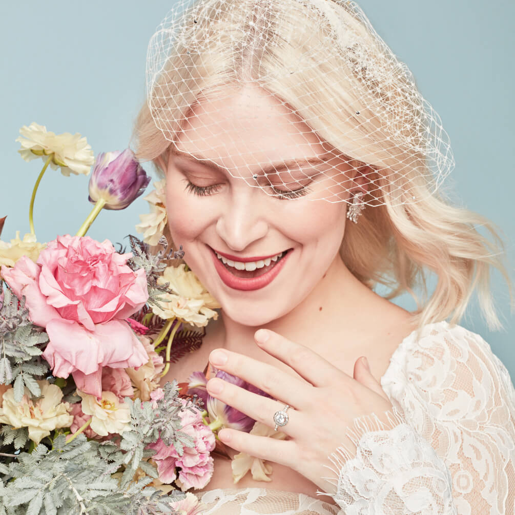 closeup of bride showing her ring while holding a bouquet