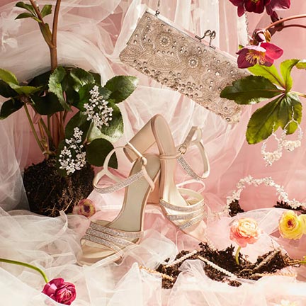 shoes, clutch, earrings, hair pins, and flowers on a table