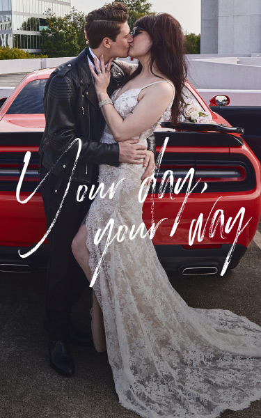 bride and groom kissing in front of their car promoting your day, your way