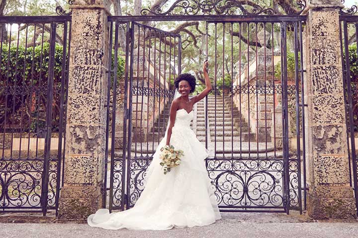 bride standing in front of a giant front gate