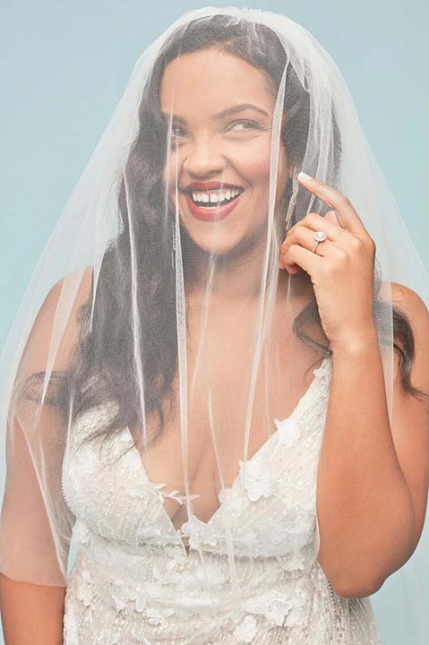 smiling bride behind a veil