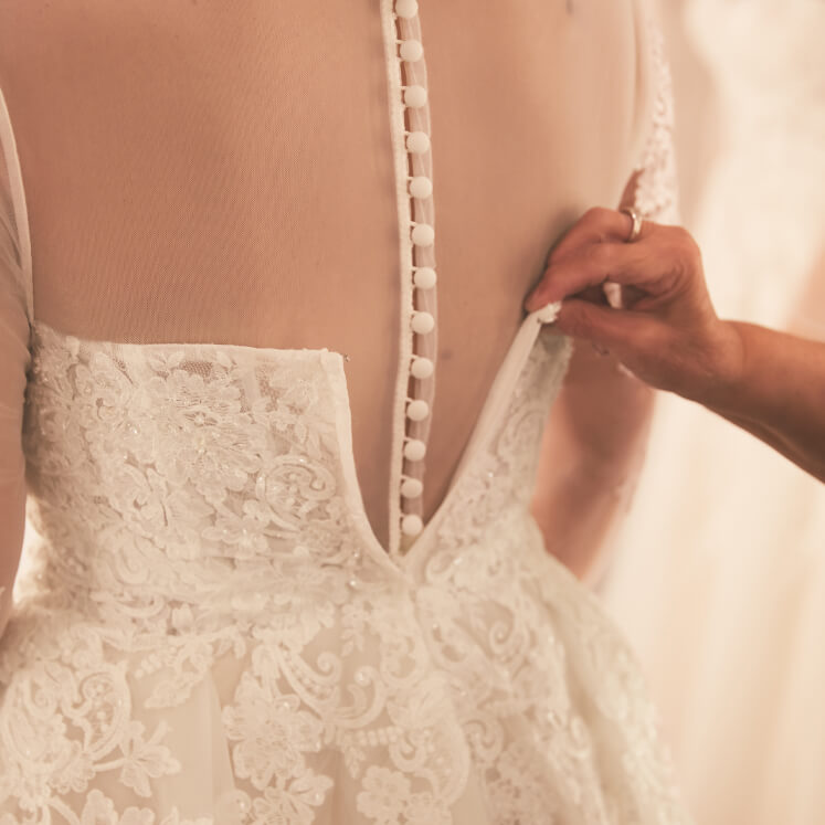 closeup of stylist measuring wedding dress
