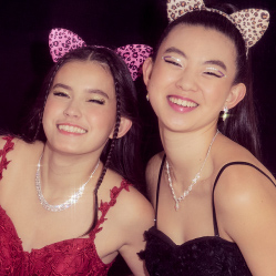 two girls in cat ears smiling for a photo