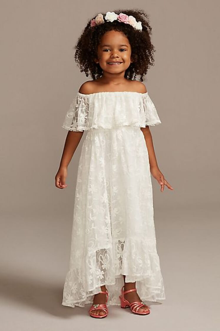 flower girl wearing an off-the-shoulder lace dress and headband smiling