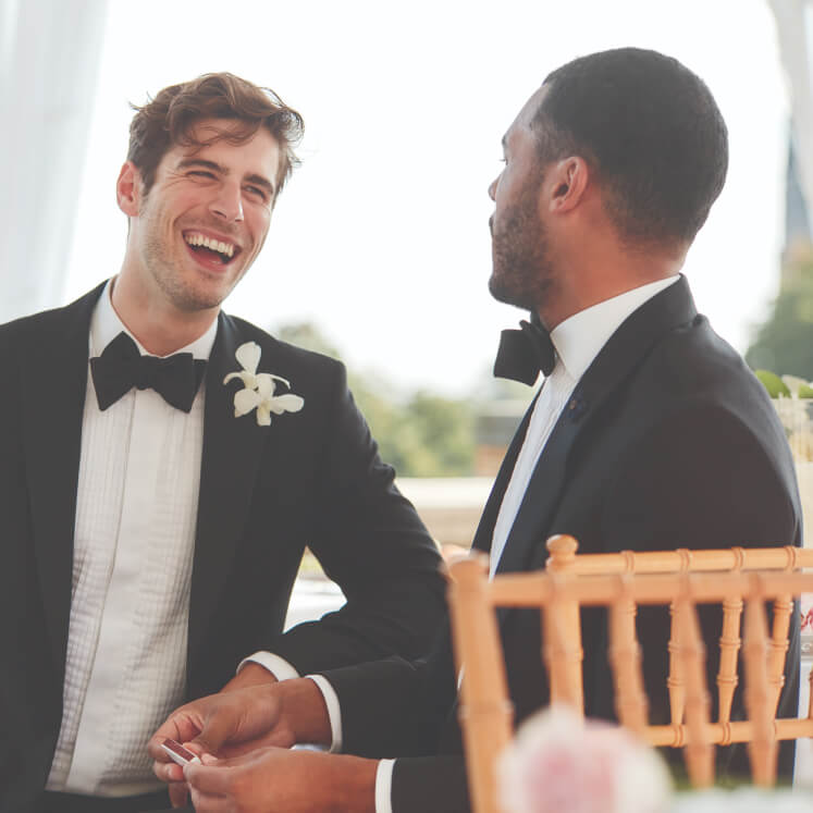 groom and groomsman sitting and laughing