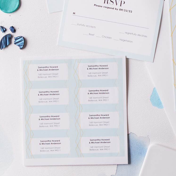 wedding rsvp cards and address stickers on a table