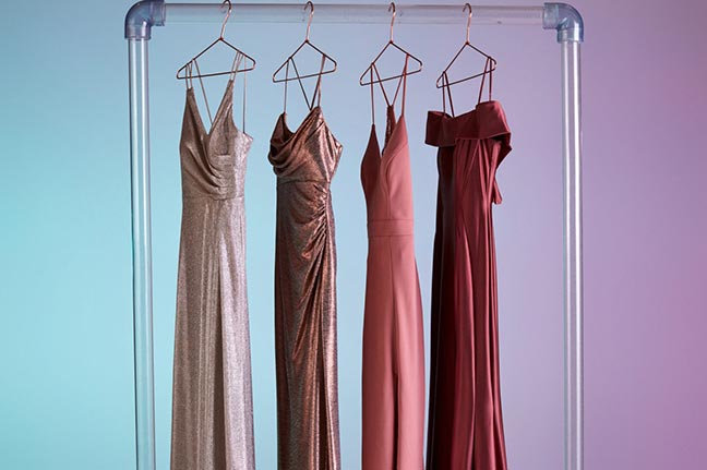 4 different silver, gold, pink, and red dresses hanging on a dress rack