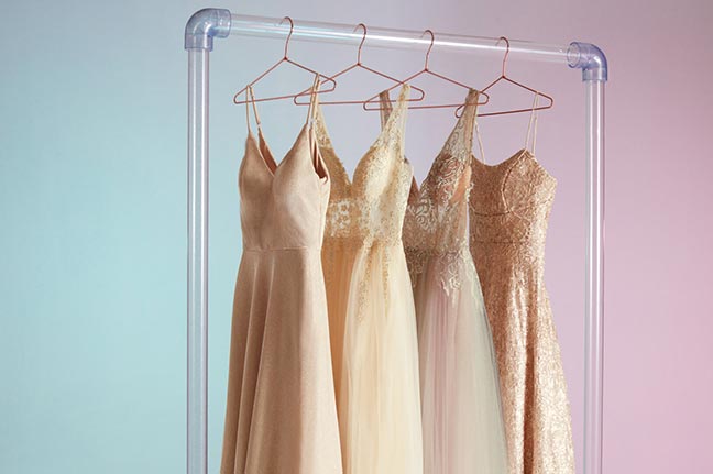 4 different white dresses hanging on a dress rack