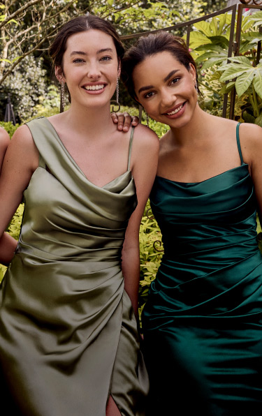 two bridesmaids in green dresses laughing