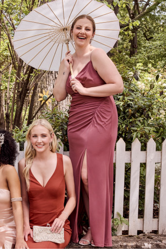bridesmaid with parasol posing with party