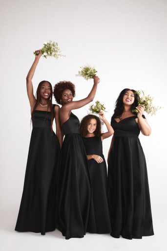 3 bridesmaids and a junior bridesmaids in black amore dresses with their bouquets raised