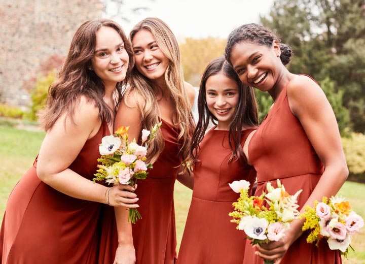 3 bridesmaids and a junior bridesmaids in cinnamon dresses posing
