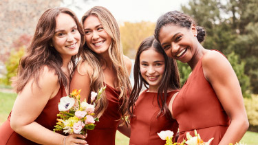3 bridesmaids and a junior bridesmaids in cinnamon dresses posing