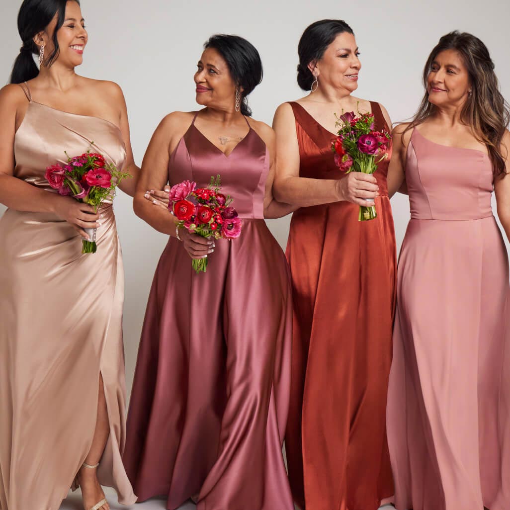 group of bridesmaids in different color dresses standing together and holding flowers