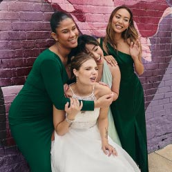 bride with her bridesmaids posing in front of mural