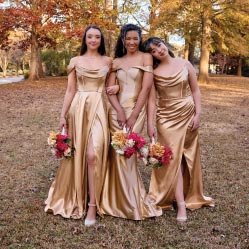 three bridesmaids in golden dresses posing outside