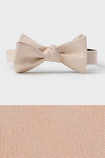 champagne colored bow tie on top of a champagne colored fabric swatch