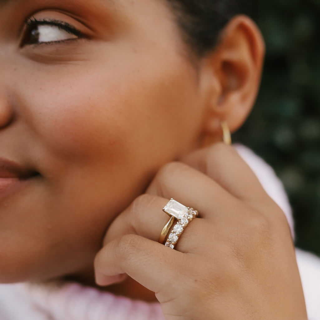 woman wearing rings with hand resting on face
