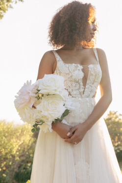 bride holding flower bouquet looking over shoulder