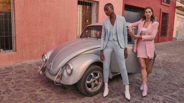 2 woman in indochino apparel standing in front of a volkswagen beetle promoting indochino
