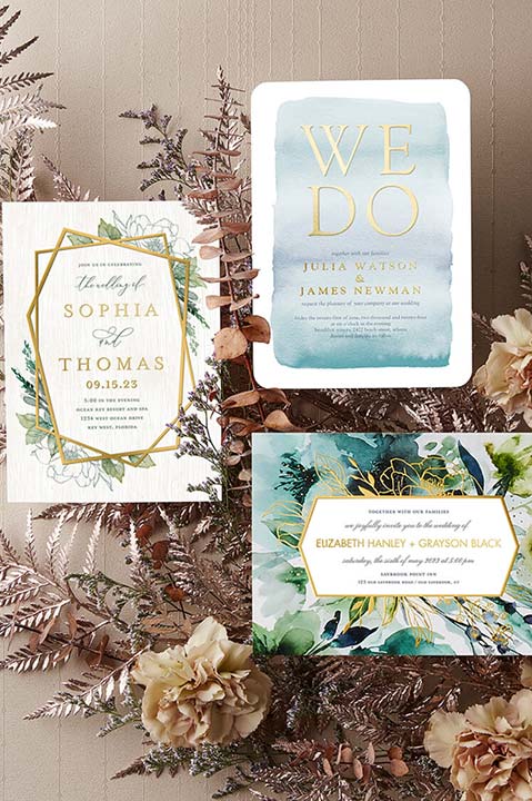 wedding invitations on top of branches and flowers