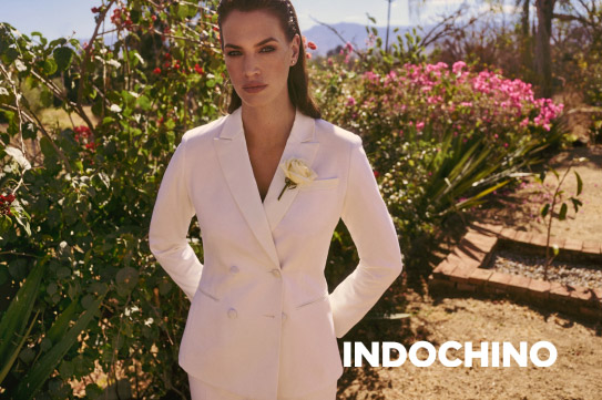 woman in white Indochino suit standing outside in a garden