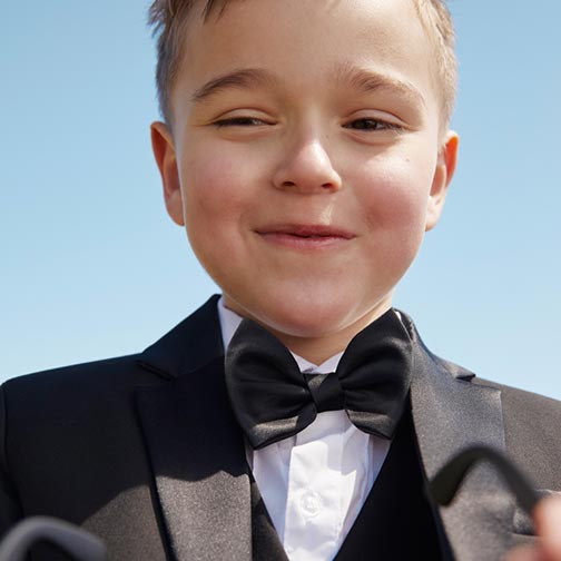 smiling boy wearing a tuxedo and bow tie