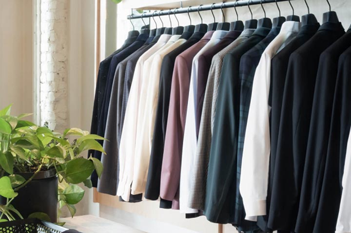multiple suit jackets in different colors hanging on a rack