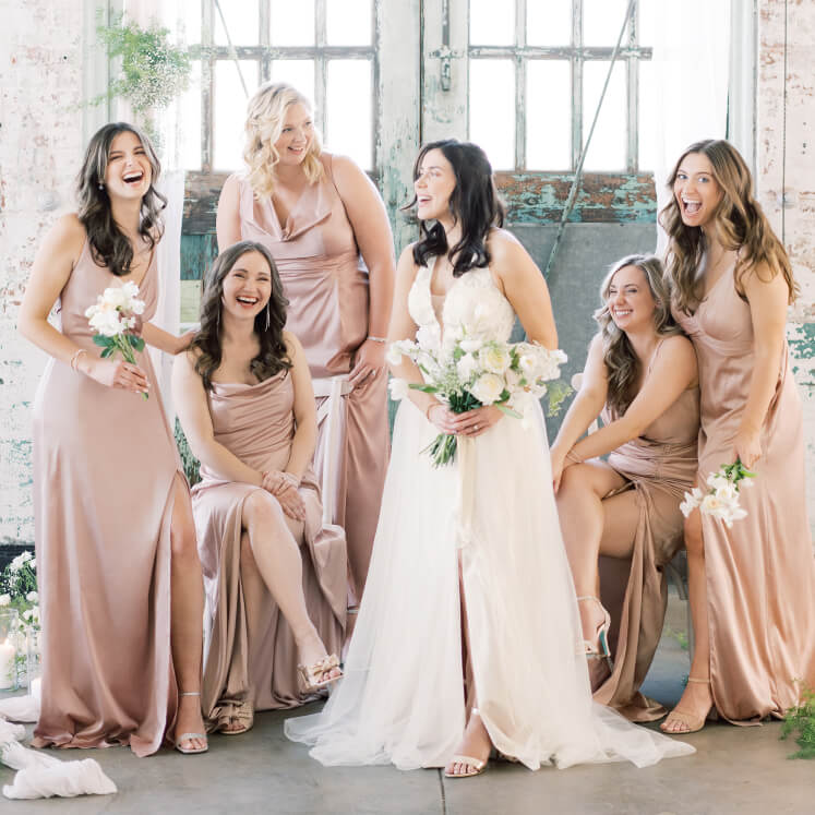 bride and her bridesmaids standing around and laughing