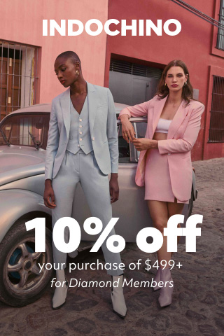 2 woman in indochino apparel standing in front of a volkswagen beetle promoting indochino 10% off your purchase of $499+ for diamond members