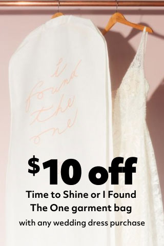 garment bag and dress hanging on a rack promoting $10 off to shine or I found the one garment bag with any wedding dress purchase
